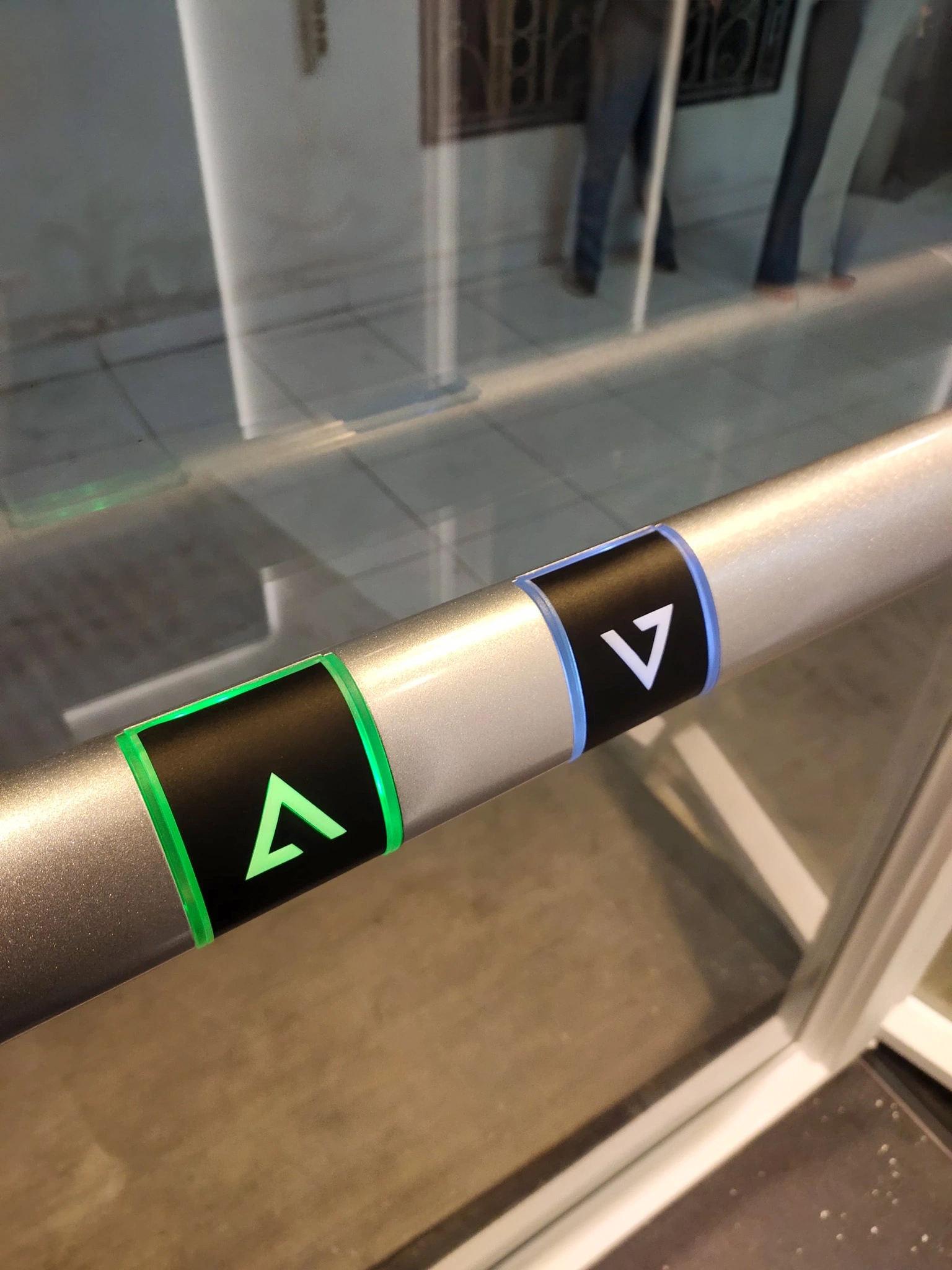 Tombol handrail lift Ascenda dengan ikon arah naik dan turun untuk kontrol yang lebih mudah
