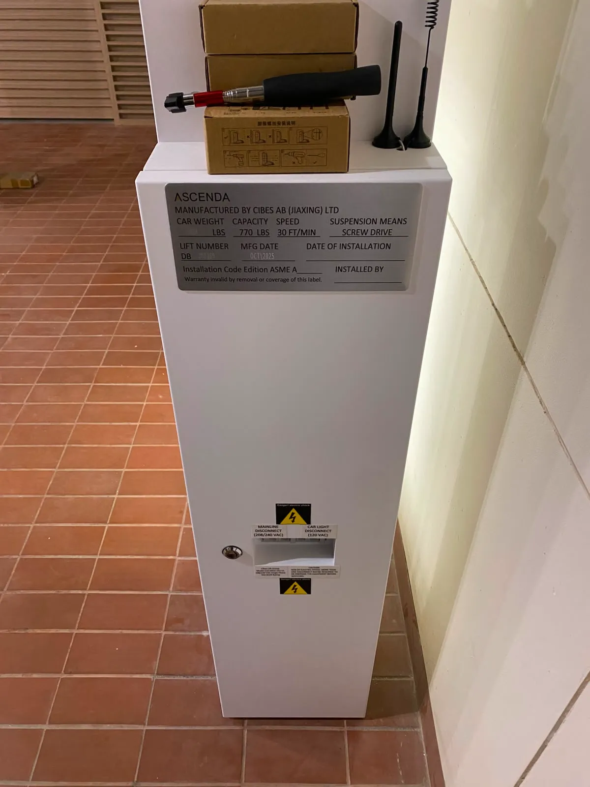 Service Lift Rumah Ascenda 2026: Biaya, Jadwal, dan Checklist Teknisi 8 Panel kelistrikan dan emergency box lift rumah Ascenda di samping struktur lift