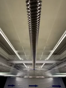 Detail screw-drive lift rumah Ascenda yang menggunakan batang ulir baja sebagai sistem penggerak