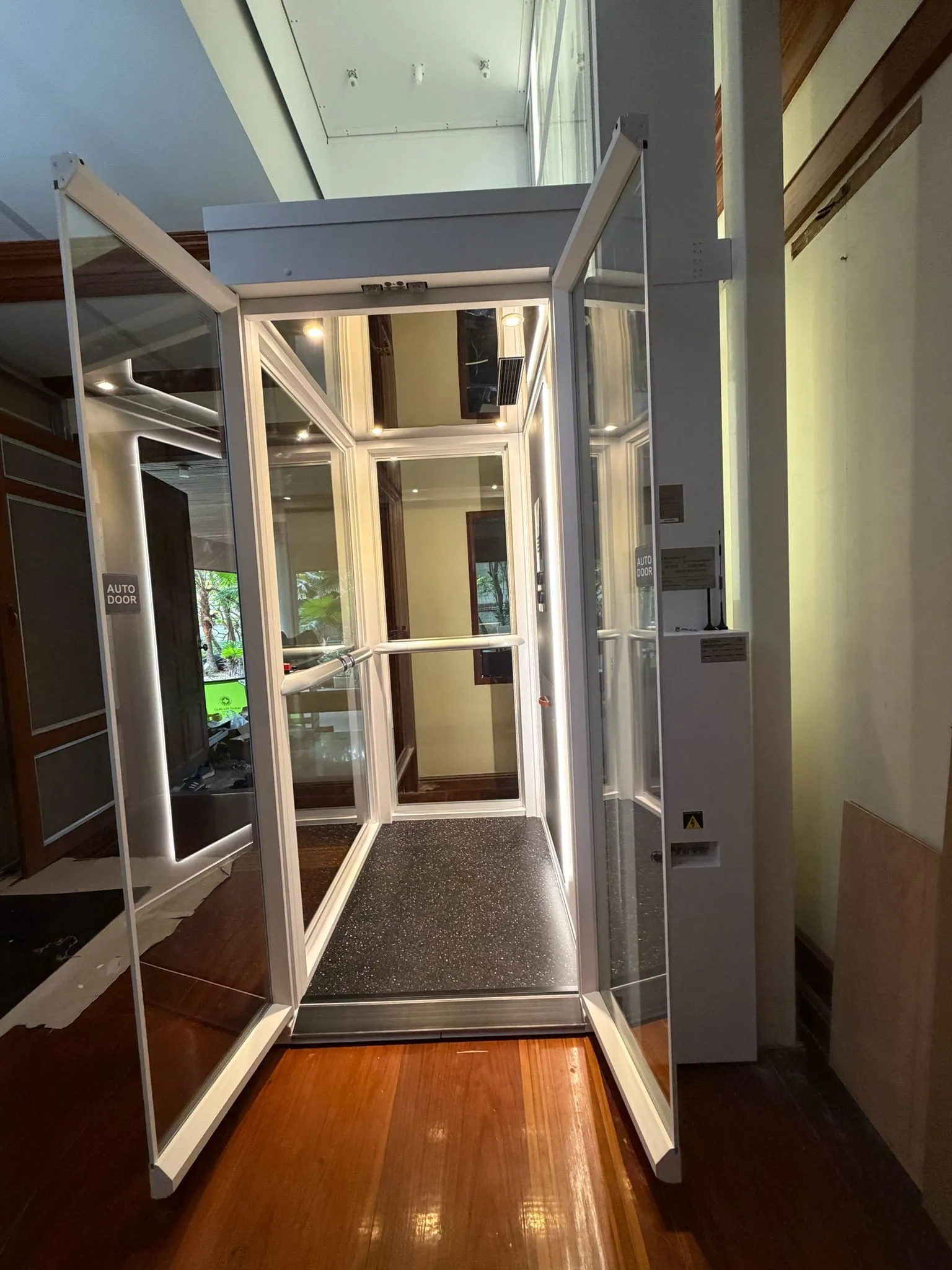 Lift rumah Ascenda terpasang di area void rumah mewah dengan sistem screw-drive dan kabin kaca